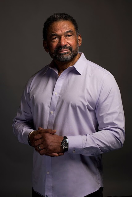 Professional headshot of Dr. Julian Agyeman, a Black man wearing a lavender button up shirt