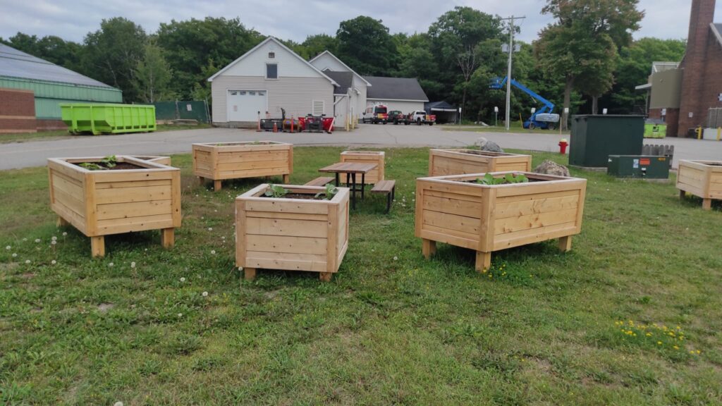 Six raised garden beds in a circle around a picnic table